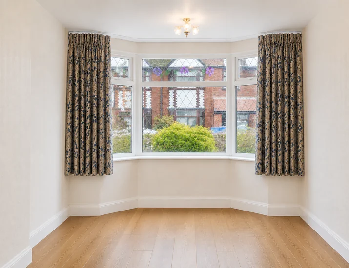 Bay window curtains that hang just past the window sill