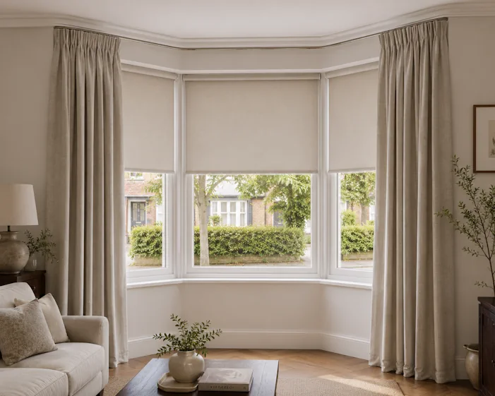 Simple roller blinds and curtains in a bay window
