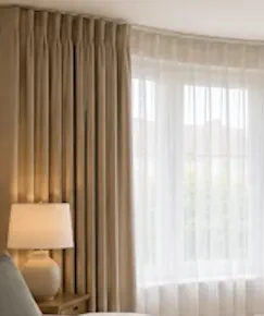 Sheer curtains behind main curtains in a bay window