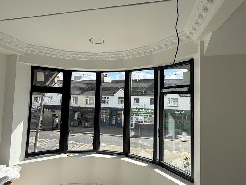 Awkward bay window with a deep bulkhead, decorative coving and several different ceiling levels